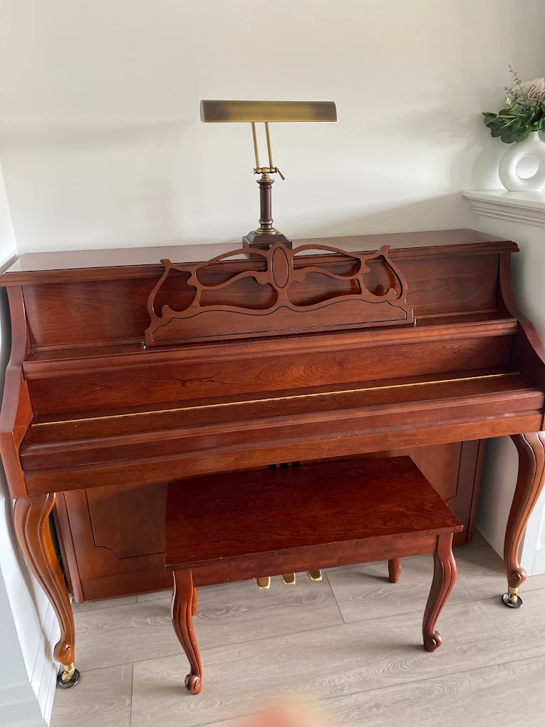 A wooden console piano in a home