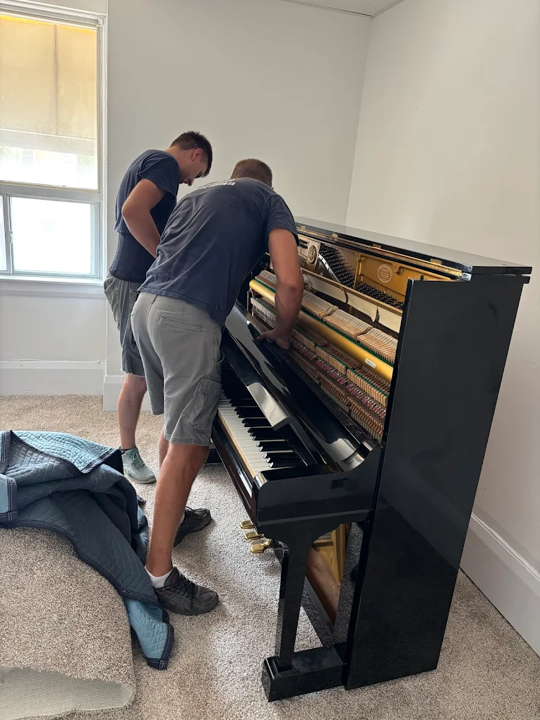 Easy Moving specialists preparing an upright piano for transport